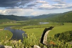 River running through landscape with mountain range in background